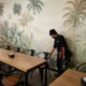 Pest control professional in protective suit inspecting for ant infestation inside a Malaysian home